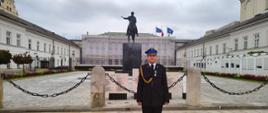 Zdjęcie przedstawia sekc. Filipa Bąka stojącego przed Pałacem Prezydenckim.