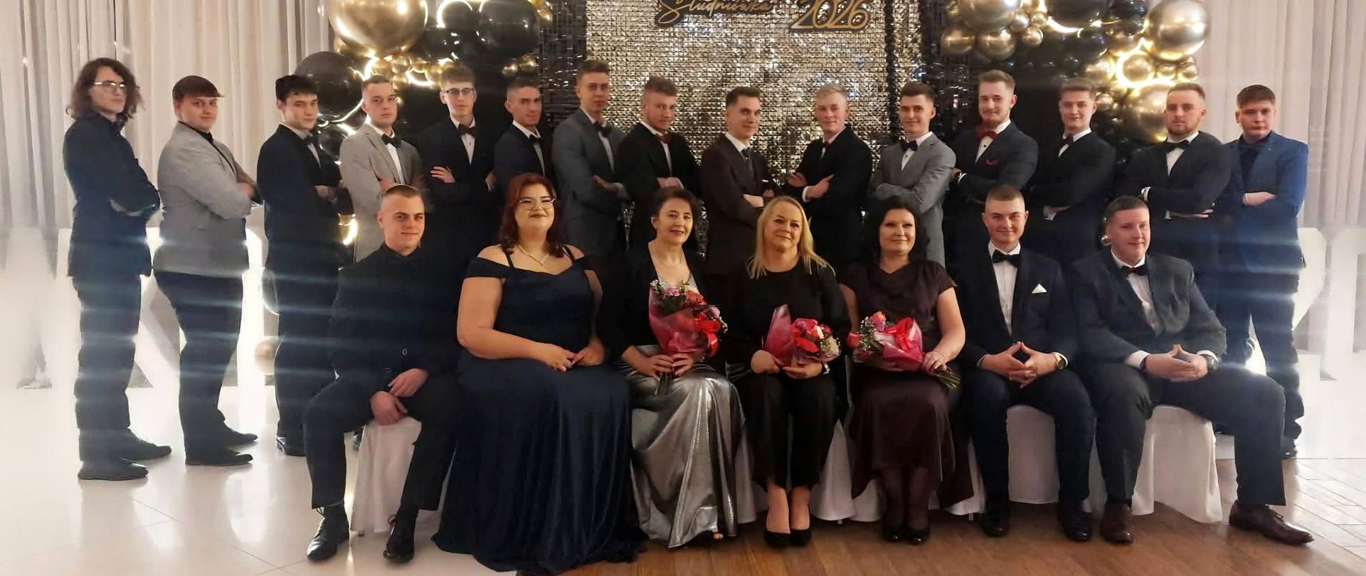 Młodzież z wychowawcami pozuje do zdjęć na balu studniówkowym.