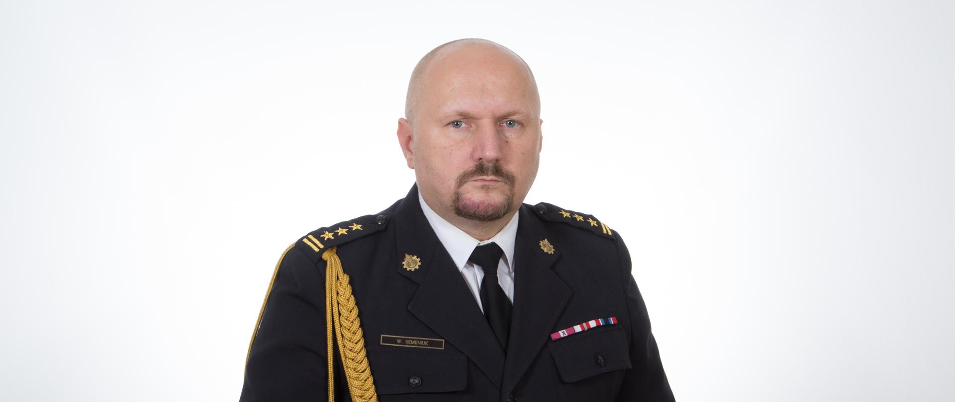 Zdjęcie portretowe komendanta st. bryg. Wojciecha Semeniuka na jasnym tle w mundurze galowym.