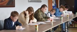 Zdjęcie przedstawia uczestników konkursu podczas pisania testu wiedzy.