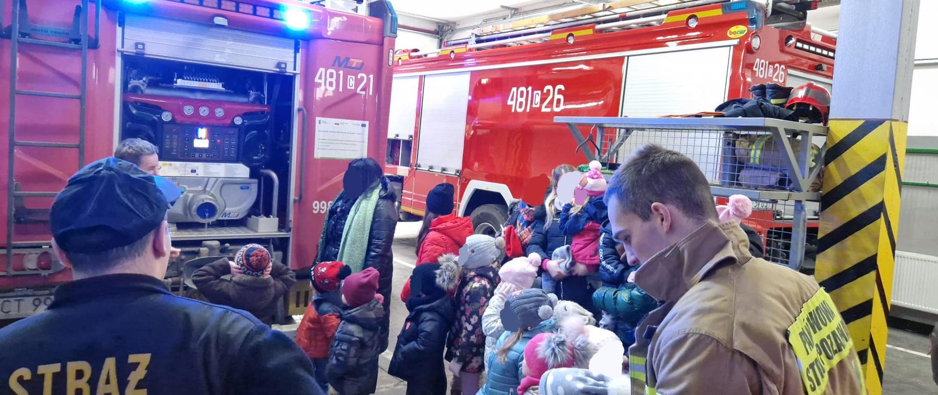 Strażacy pokazują dzieciom samochody pożarnicze