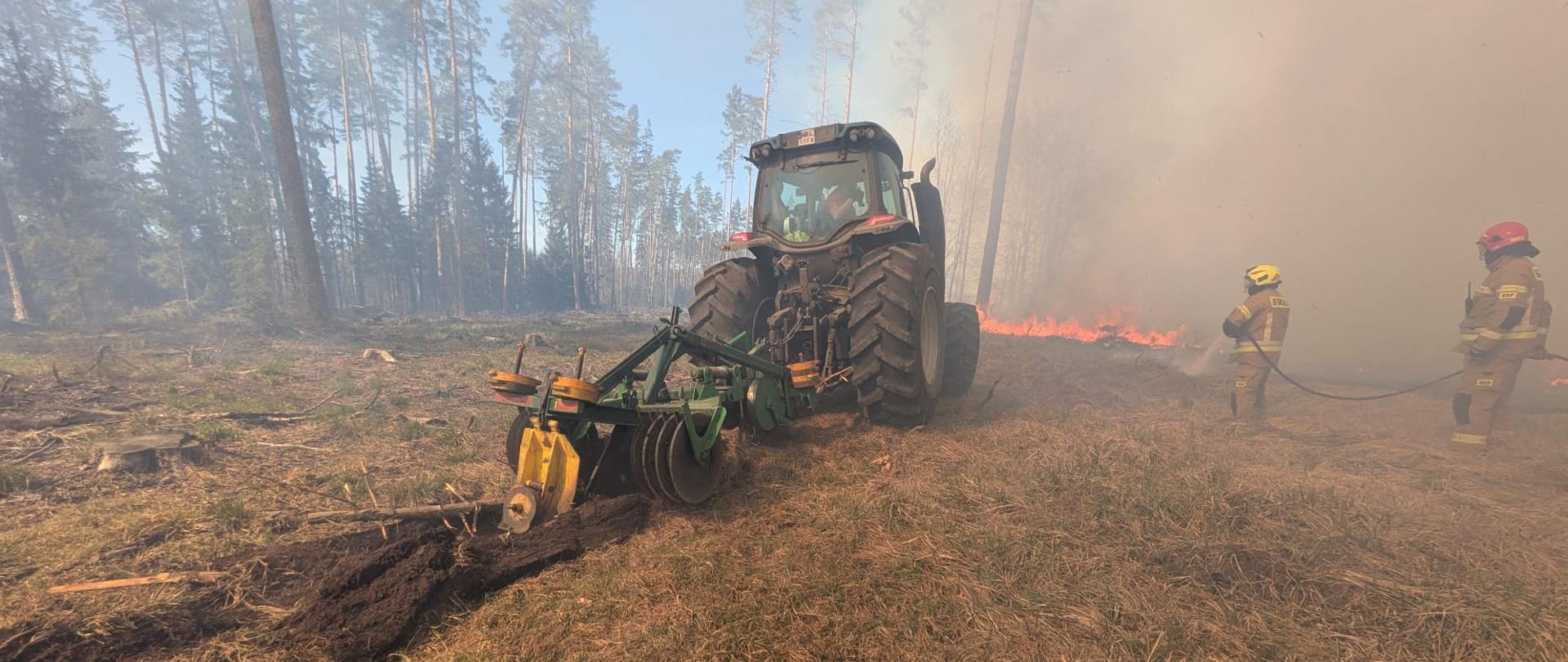 Widoczny ciągnik tworzący rów (pas zaporowy) mający na celu powstrzymanie rozprzestrzeniania się pożaru.