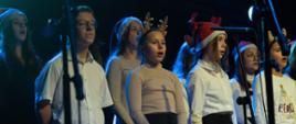 Zdjęcie przedstawia chór szkolny PSM I stopnia w Jarocinie podczas występu na koncercie świątecznym.