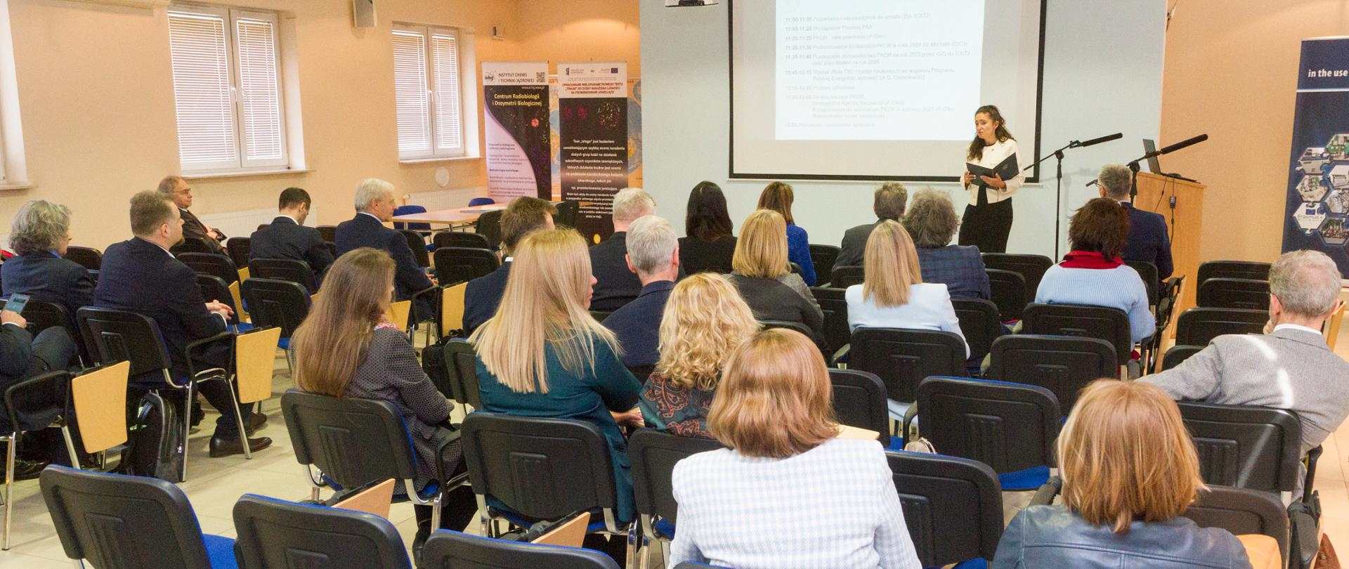 Sala, na której odbywało się spotkanie Polskiego Konsorcjum Ochrony Radiologicznej. W tle widoczna Iga Pocztarek-Tofil podczas wystąpienia.
