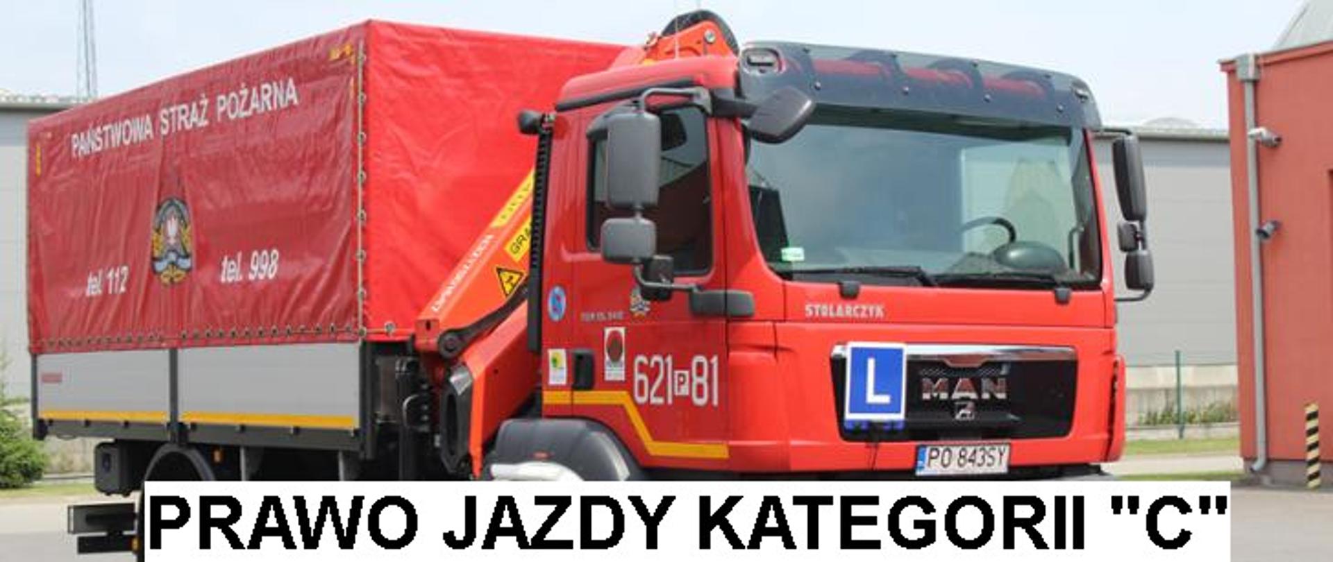 czerwony strażacki samochód firtmy man z naczepą, z przodu samochodu widoczna litera L na niebieskim tle