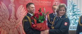 Na zdjęciu widoczny bryg. Maciej Wolański otrzymujący bukiet kwiatów od przedstawiciela funkcjonariuszy i pracowników cywilnych KM PSP w Tarnowie w osobie bryg. Joanny Chorabik.