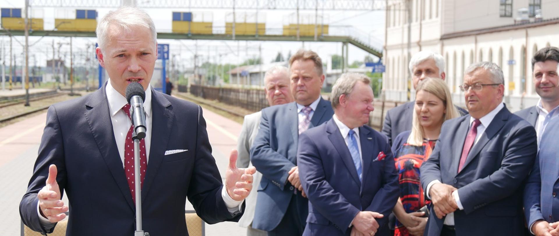 zdjęcie przedstawia konferencje prasową ministra na peronie kolejowym