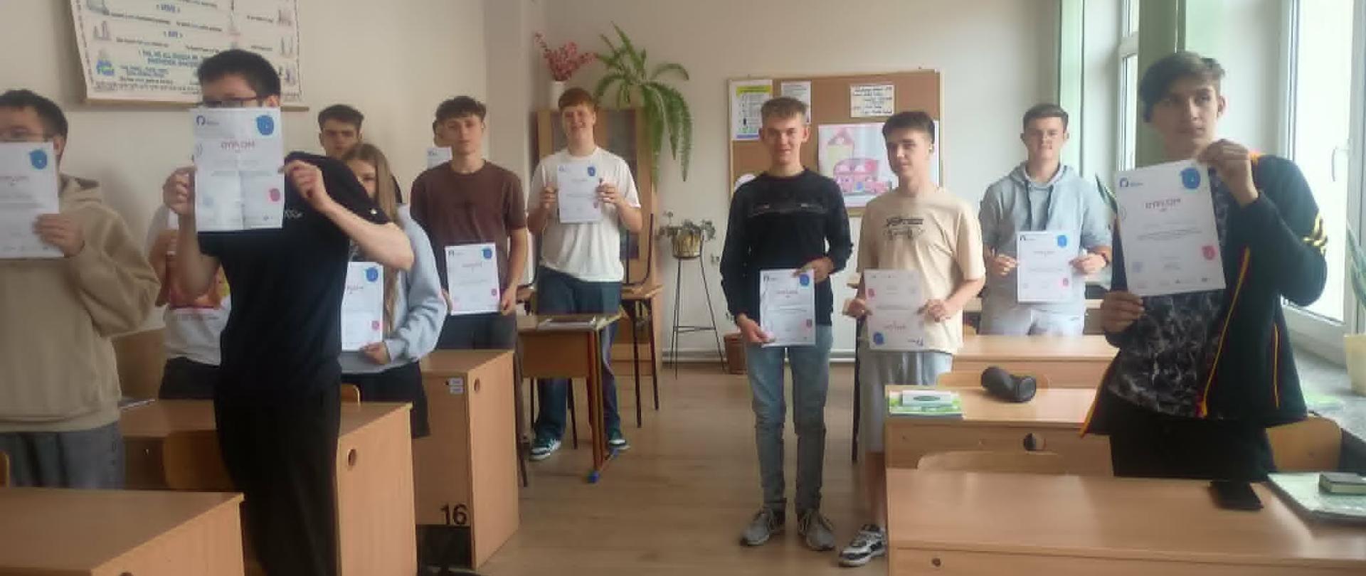Uczniowie prezentują certyfikaty ukończenia programu „Kurs na Odporność” podczas podsumowania działań w klasie.