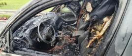 Pożar auta na S5. Jezdnia trasy S5 w kierunku Poznania. Wnętrze wraku spalonego samochodu osobowego.