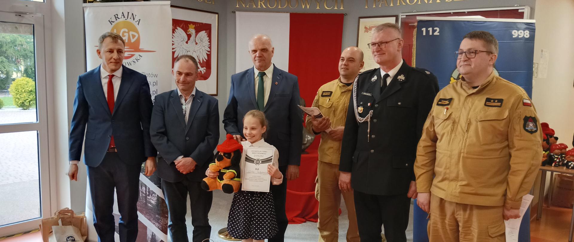 Na zdjęciu ludzie w tle banery