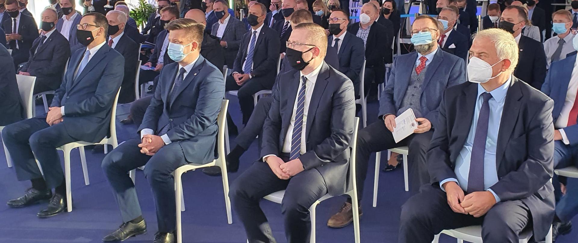 Uroczystość wmurowania kamienia węgielnego pod fabrykę w Środzie Śląskiej. Goście słuchają przemówień.