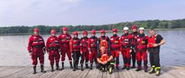 Na zdjęciu strażacy podczas szkolenia na jeziorze, strażacy stoją do zdjęcia pamiątkowego na pomoście w strojach nurkowych