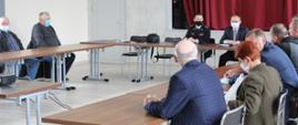 Na sali narad uczestnicy spotkania siedzą za stołami. Widoczni są Zastępca Komendanta Miejskiego PSP w Łomży, wójt gminy Śniadowo oraz członkowie ochotniczych straży pożarnych.