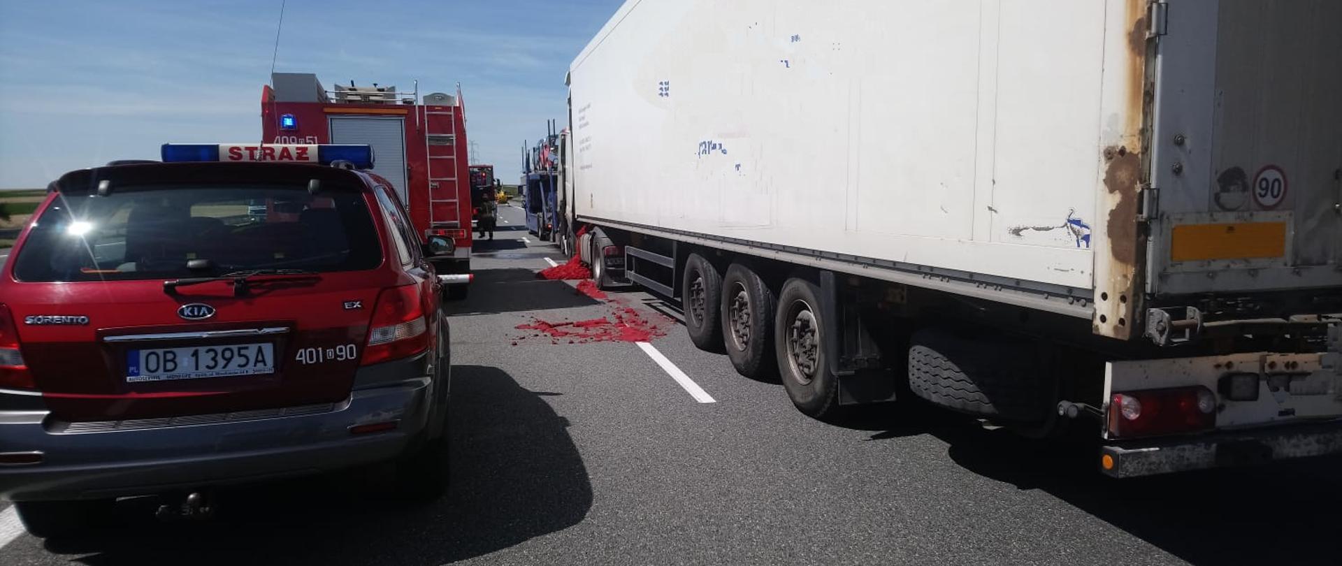 Wypadek z udziałem 3 samochodów ciężarowych na autostradzie A4 - zdjęcie przedstawia samochody ciężarowe biorące udział w zdarzeniu. Po lewej stronie ustawione są samochody straży pożarnej.