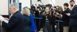 Minister Funduszy i Polityki Regionalnej Katarzyna Pełczyńska Nałęcz idzie w sali posiedzeń rządu, za jej plecami fotoreporterzy