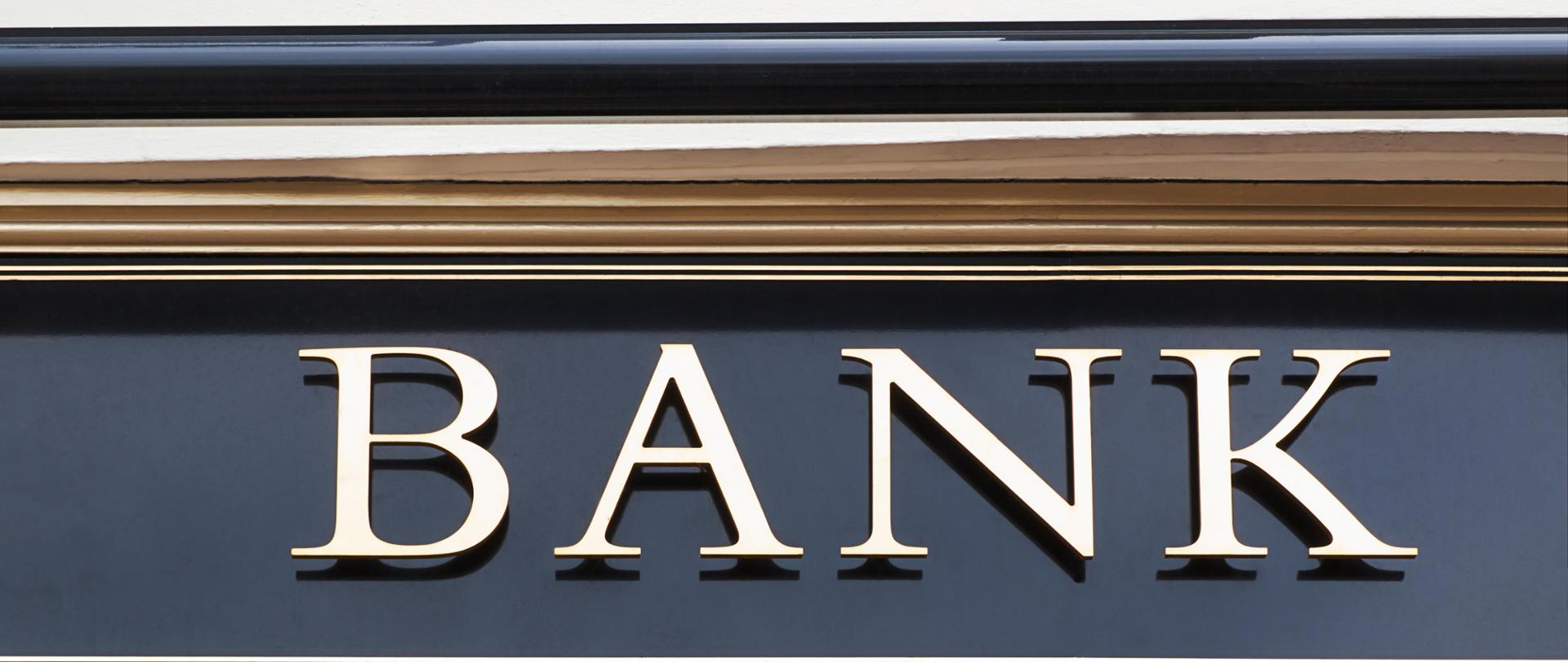 Napis bank na szarym tle budynku