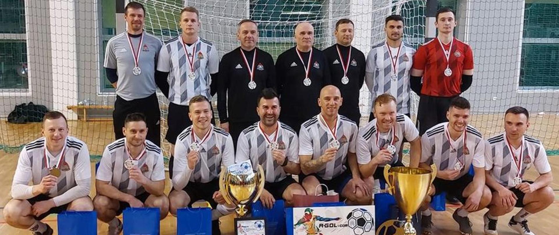 drużyna piłkarzy pozuje do zdjęcia w sali sportowej