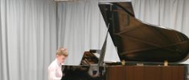 wyk. Zuzanna Borowiecka, uczeń szkoły grający na czarnym fortepianie