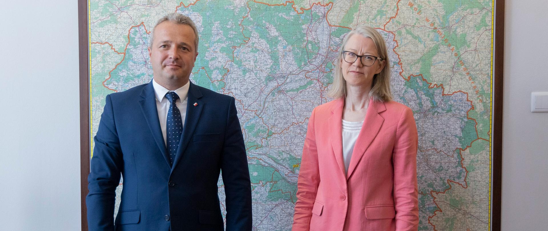 
2 osoby stojące na tle mapy
