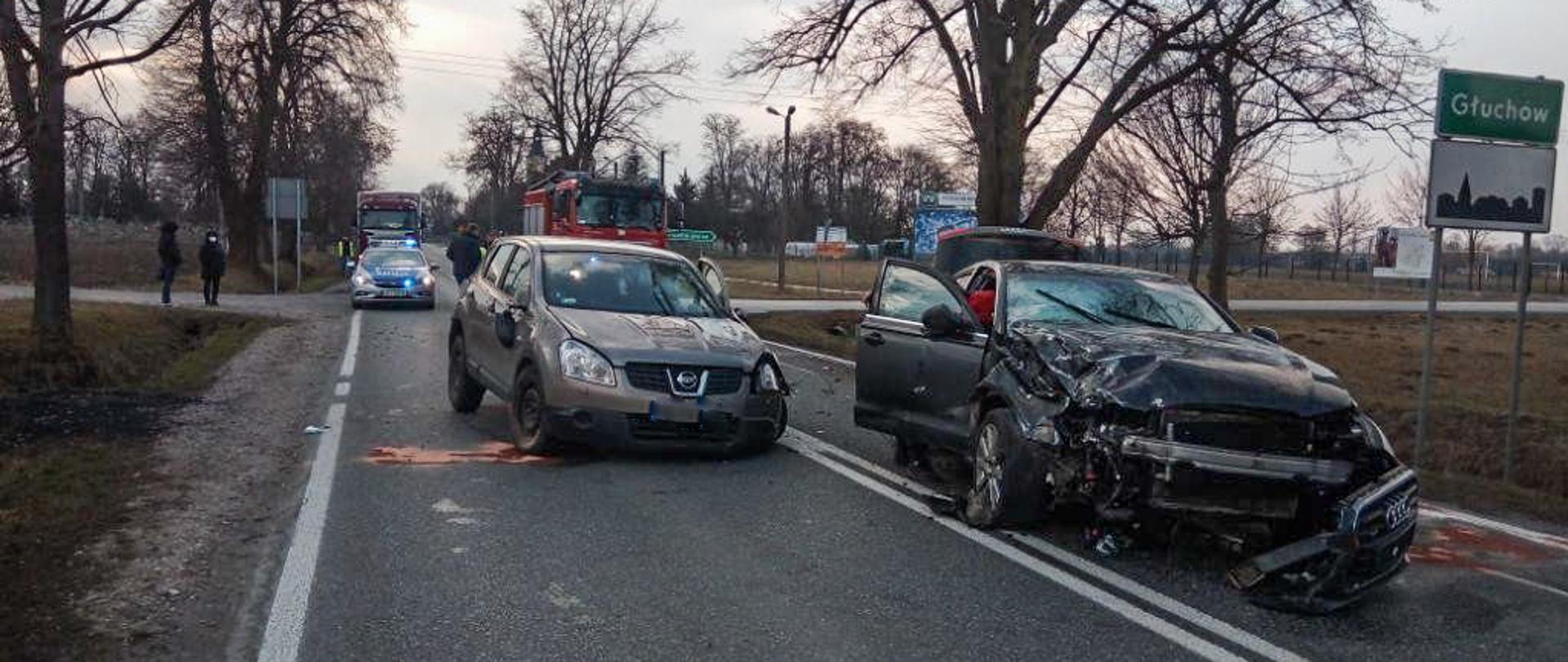 Zdjęcie przedstawia rozbite pojazdy na drodze krajowej nr 72 w Głuchowie oraz pojazd straży pożarnej i policji.