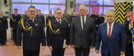 Wręczenie nagrody Komendanta Głównego Państwowej Straży Pożarnej funkcjonariuszowi mł. bryg. Piotrowi Frankenstein. Wręczenia dokonali Zastępca Pomorskiego Komendanta Wojewódzkiego PSP bryg. Wojciech Berent, Wicewojewoda Pomorski Pan Mariusz Łuczyk, Poseł na Sejm RP Pan Aleksander Mrówczyński. W tle strażacy stoją w dwuszeregu.