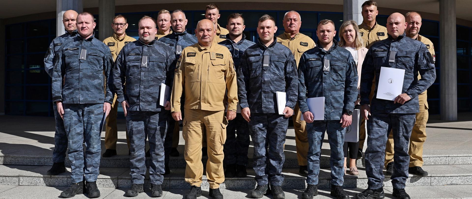 Pamiątkowe zdjęcie grupowe funkcjonariuszy Straży Marszałkowskiej (8 osób) w towarzystwie Komendanta Centralnej Szkoły PSP, kobiety oraz sześciu funkcjonariuszy wydziału nauczania CS PSP