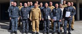 Pamiątkowe zdjęcie grupowe funkcjonariuszy Straży Marszałkowskiej (8 osób) w towarzystwie Komendanta Centralnej Szkoły PSP, kobiety oraz sześciu funkcjonariuszy wydziału nauczania CS PSP