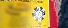 Gaśnica samochodowa z nalepką wskakująca termin następnego przeglądu. Legalizacja skończyła się ponad rok temu.