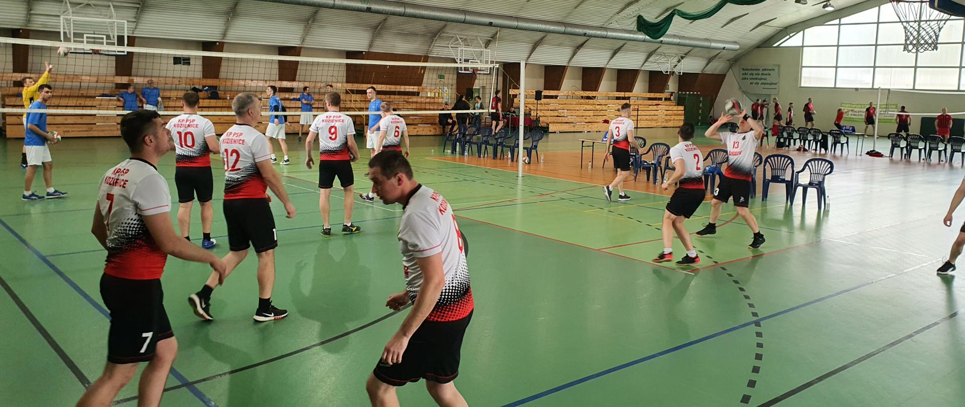 zawodnicy na boisku piłki siatkowej podczas rozgrzewki