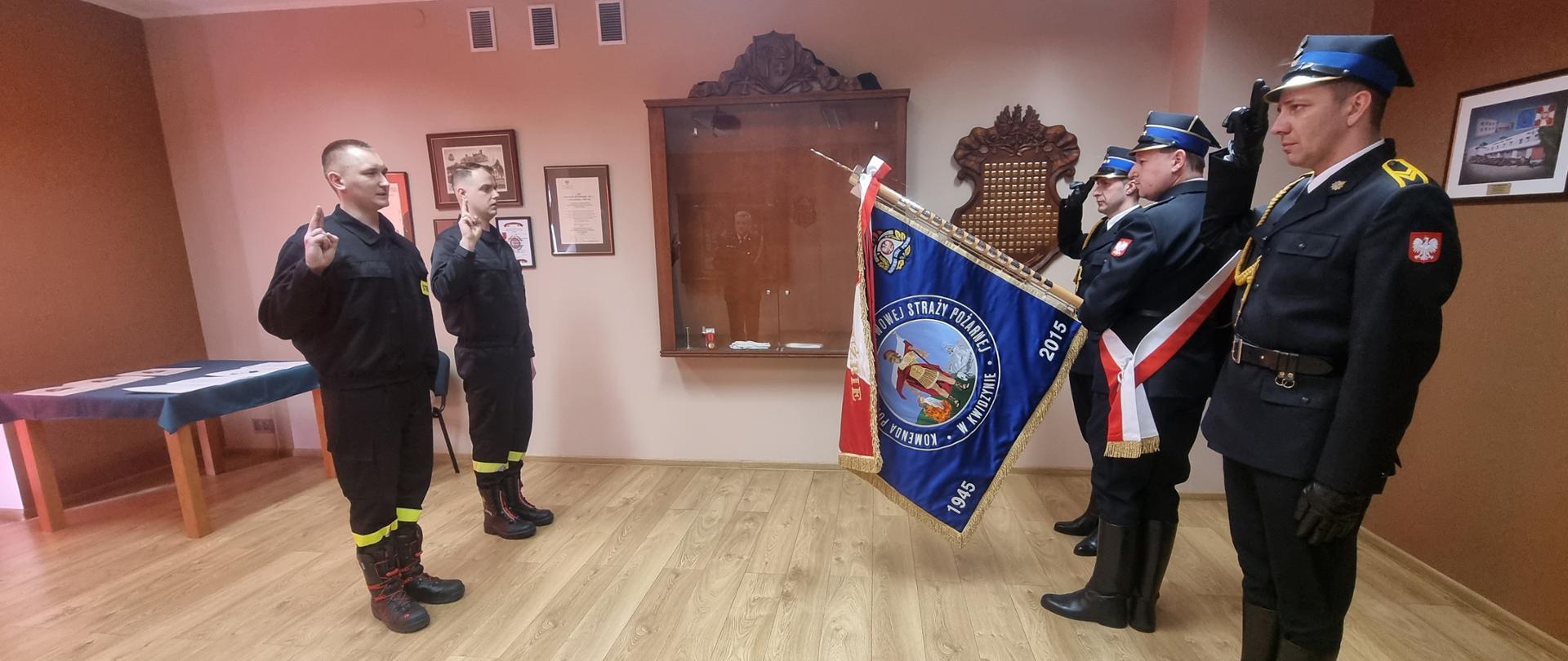 Dwaj strażacy podczas ślubowania przed sztandarem