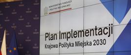 Obrady Rady Wykonawczej ds. wdrażania Krajowej Polityki Miejskiej 2030, na telebimie napis: Plan Implementacji Krajowej Polityki Miejskiej 2030