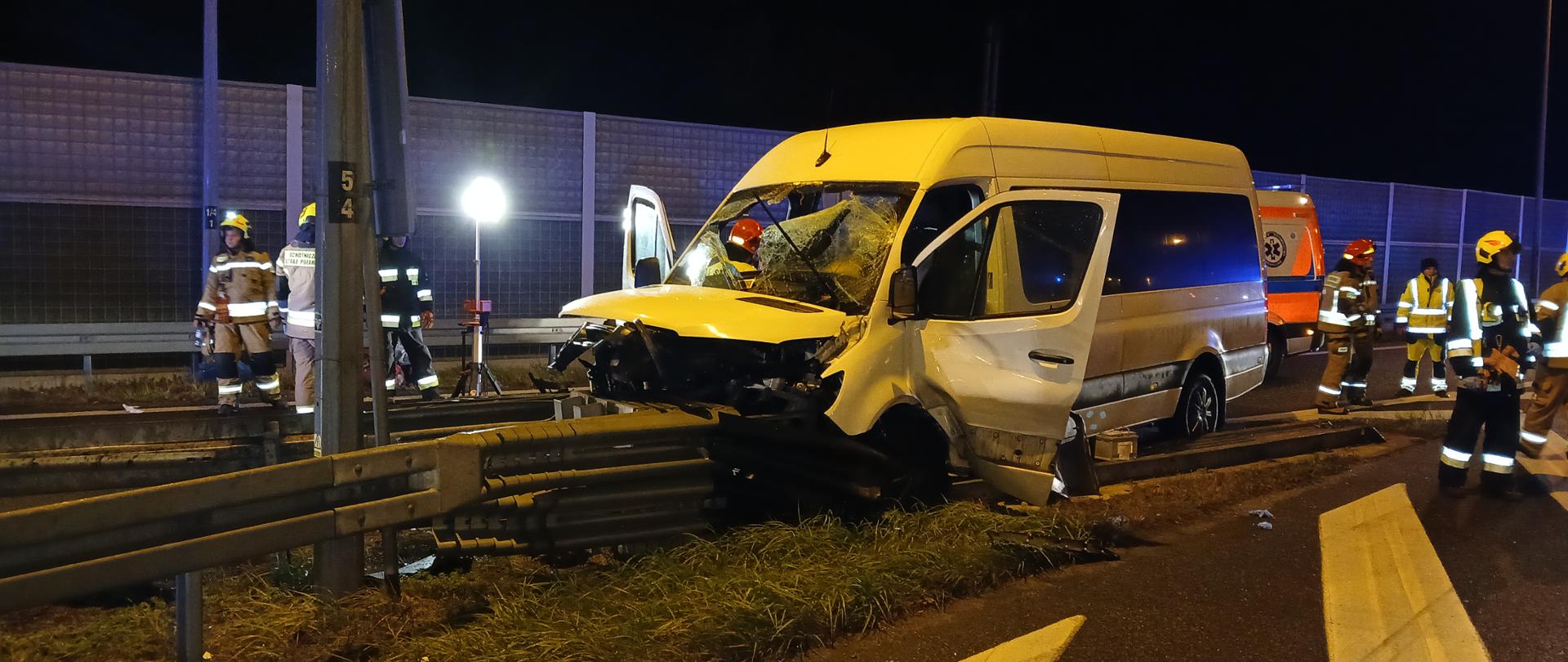 Na zdjęciu widoczny biały bus pasażerski wbity w bariery energochłonne zjazdu miejsca obsługi podróżnych (MOP) na autostradzie A4.