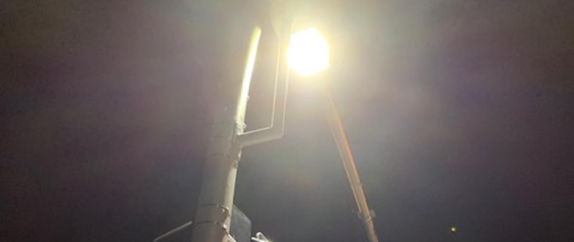 Zdjęcie przedstawia dodatkowe doświetlenie przejścia dla pieszych na wysięgniku zamontowanym koło przejścia.