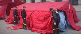 Czerwony namiot rozkładany przez strażaków