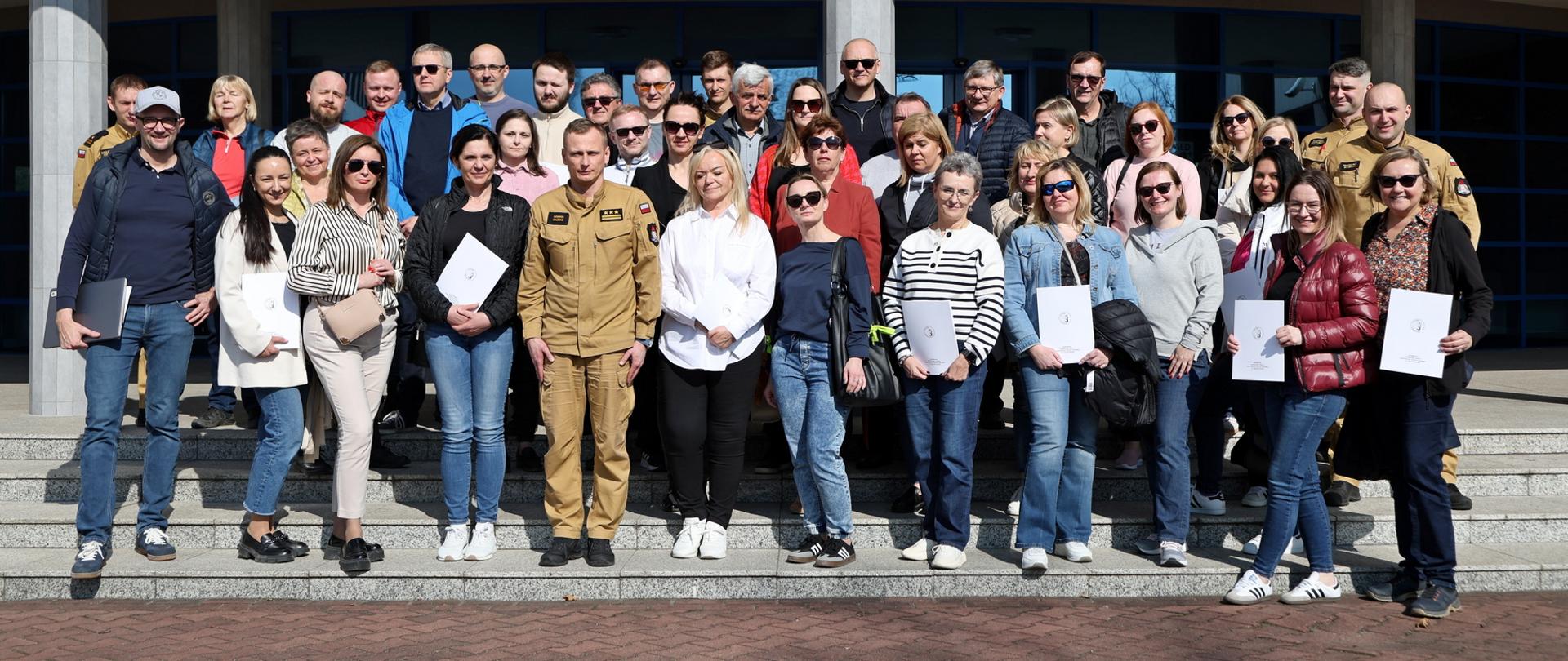 Pamiątkowe zdjęcie grupowe pracowników Ergo Hestia będących uczestnikami szkolenia z zakresu ochrony przeciwpożarowej (37 osób) w towarzystwie Zastępcy Komendanta Centralnej Szkoły PSP oraz czterech funkcjonariuszy CS PSP