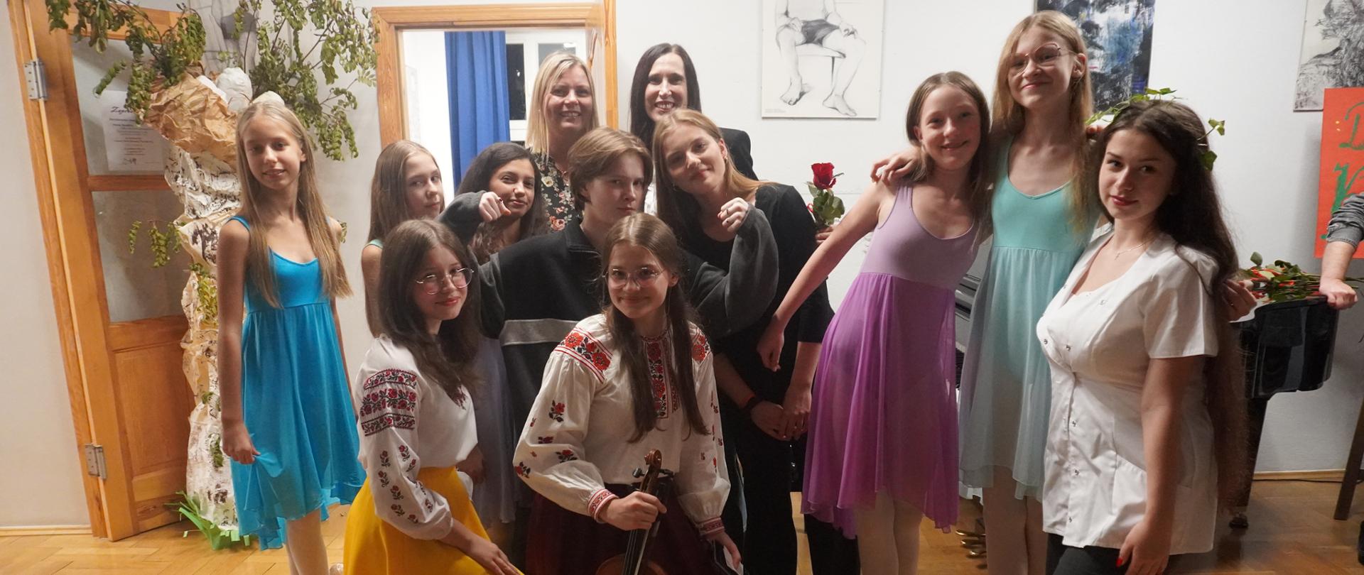 Artyści razem z Panią Dyrektor pozują do zdjęcia grupowego. 