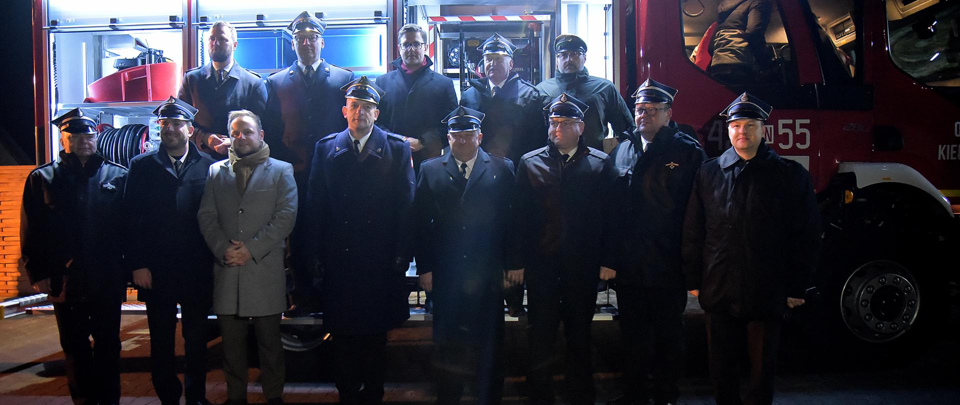 Zaproszeni goście stoją na tle nowego samochodu ratowniczo-gaśniczego