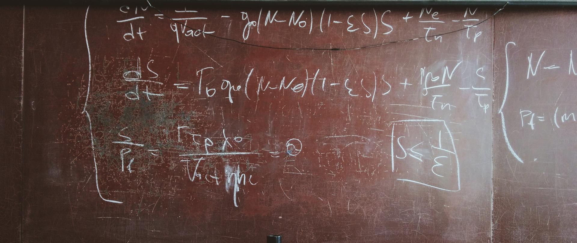 tablica szkolna z napisanym białą kredą działaniem matematycznym