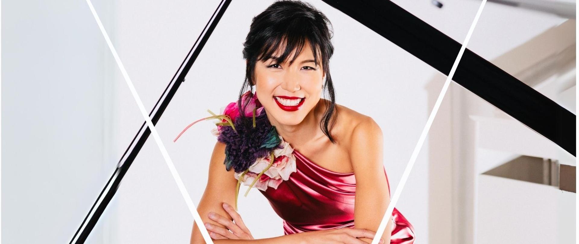 Na białym tle szczegóły koncertu Rachel Naomi Kudo. Na zdjęciu kobieta o azjatyckiej urodzie opiera się o fortepian FAZIOLI