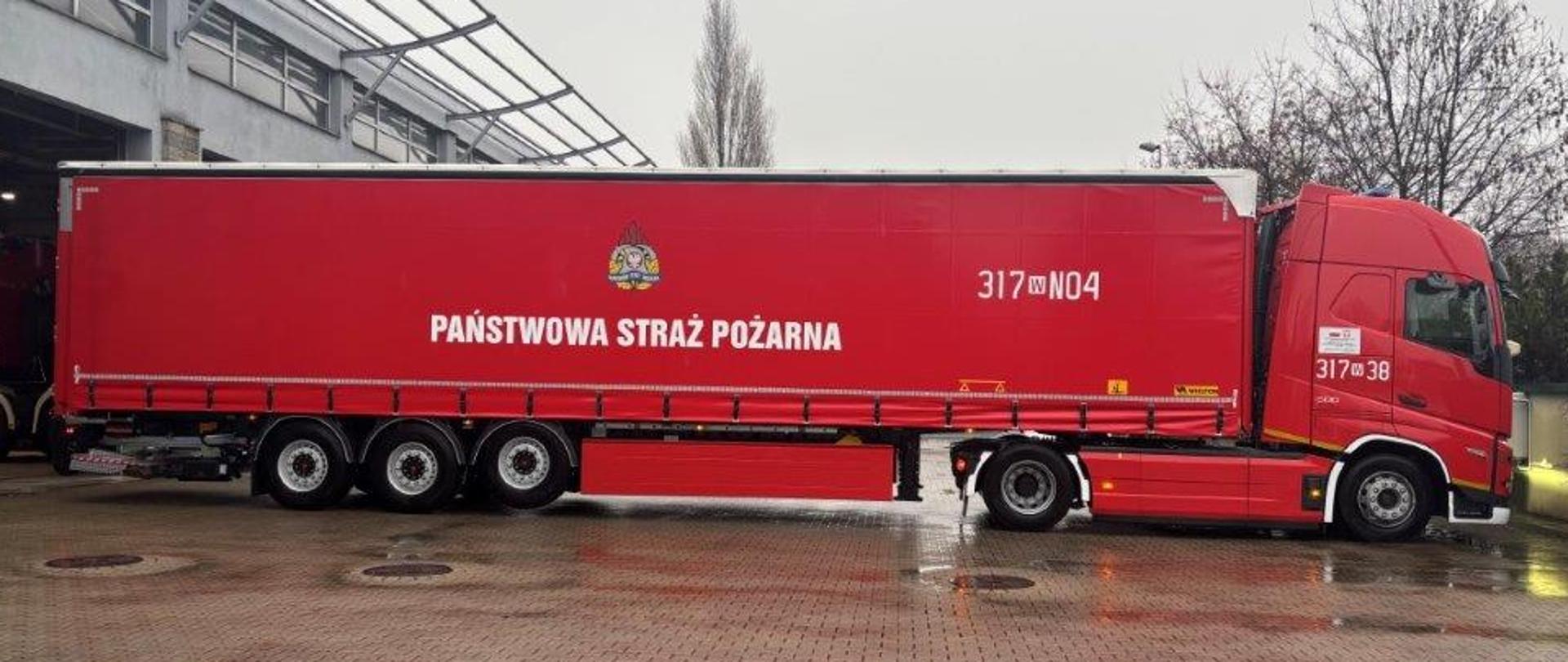 Na zdjęciu czerwony TIR z napisem PAŃSTWOWA STRAŻ POŻARNA. 