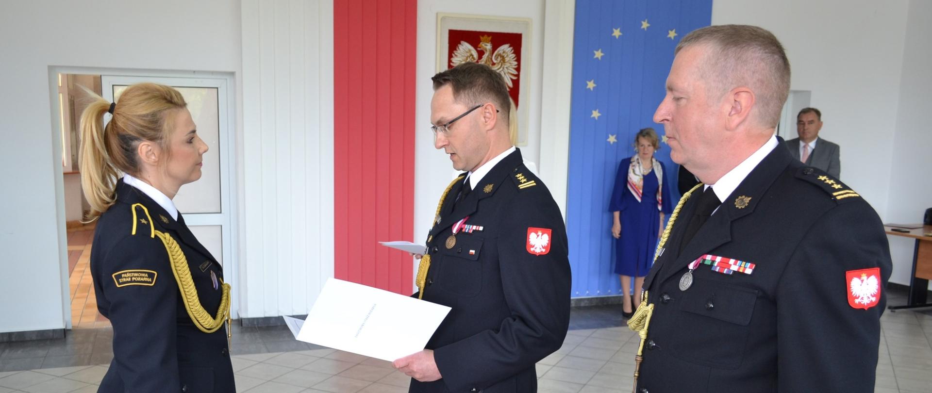 Z-ca komendanta wojewódzkiego gratuluje nagrodzonemu strażakowi 