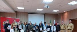 XLVI powiatowe eliminacje Ogólnopolskiego Turnieju Wiedzy Pożarniczej pt. „Młodzież Zapobiega Pożarom” - zdjęcie pamiątkowe ze zwycięzcami turnieju