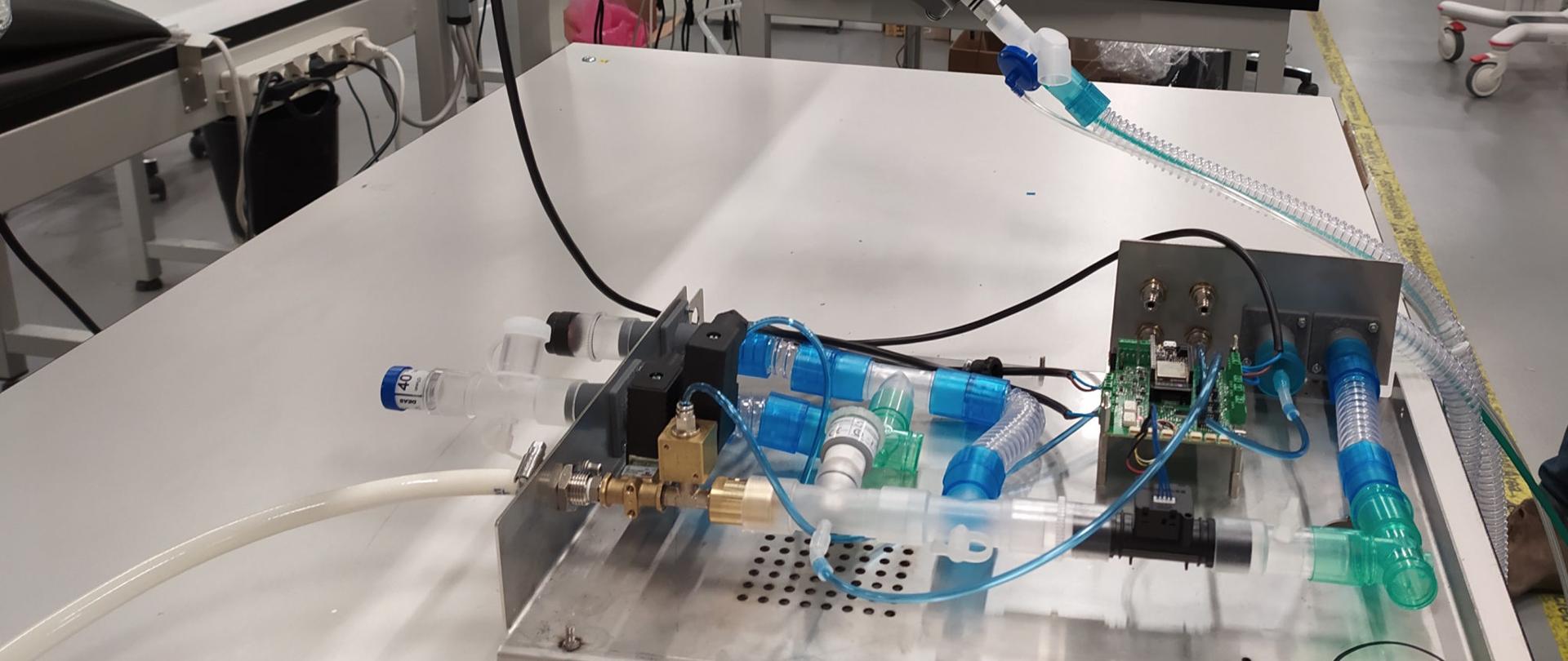 Respirator MVM w trakcie testowania - urządzenie bez obudowy leży na stole.