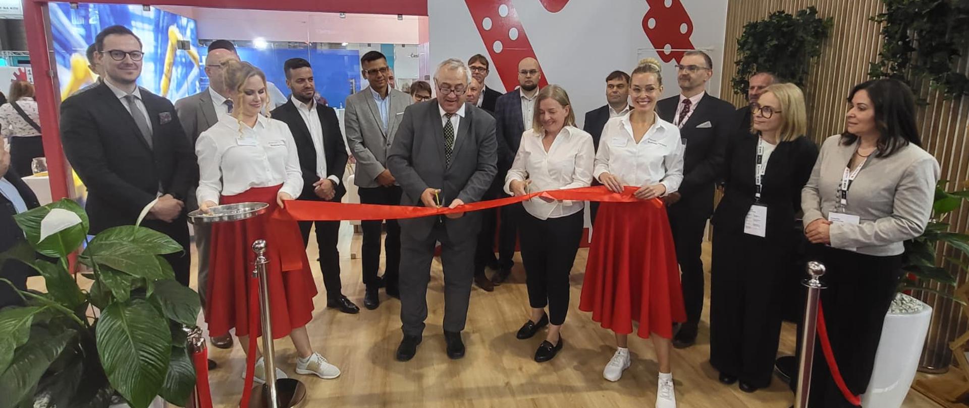 Dwoje dyplomatów otwierają polskie stoisko na Targach MSV za pomocą cięcia wstęgi