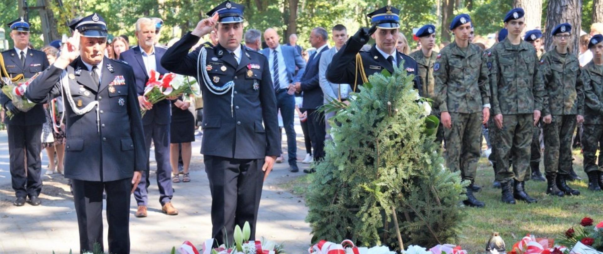 Zdjęcie zrobione podczas uroczystości w intencji pomordowanych żołnierzy w gminie Ciepielów. Na zdjęciu delegacja strażaków oddając honory składa wieniec przed pomnikiem poległych żołnierzy