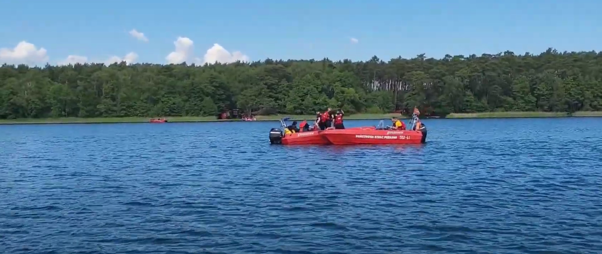 Kadr z filmu ze zgrupowanie grup wodno-nurkowych PSP woj. wielkopolskiego. 2 łodzie motorowe wraz ze strażakami PSP na jeziorze