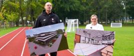 Barbara Nowacka oraz mężczyzna w czarnej bluzie sportowej stoją na czerwonej bieżni lekkoatletycznej i prezentują dwie duże tablice z wizualizacjami architektonicznymi hali sportowej.