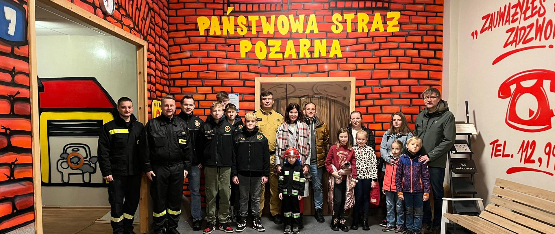 Zdjęcie strażaków z gośćmi którzy odwiedzili Centrum Edukacji Przeciwpożarowej