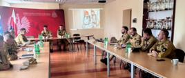 Zdjęcie obrazuje podsumowanie ćwiczeń powiatowych pod kryptonimem "Grot 2026". W podsumowaniu ćwiczeń uczestniczyli- naczelnik Wydziału Planowania Operacyjnego Komendy Wojewódzkiej PSP w Kielcach mł. bryg. Kamil Ciepielewski oraz zastępca komendanta powiatowego PSP w Jędrzejowie st. kpt. Tomasz Kwiecień oraz rozjemcy, którzy oceniali ćwiczenia.