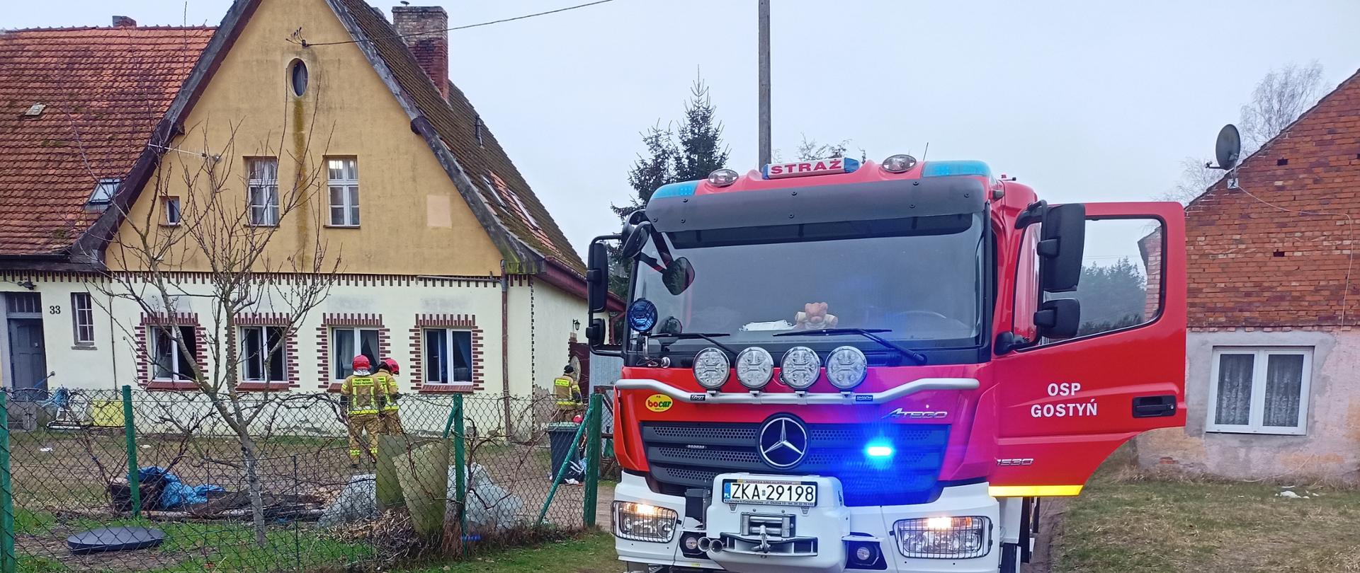 Pojazd OSP Gostyń w czasie działań gaśniczych , w tle budynki mieszkalne